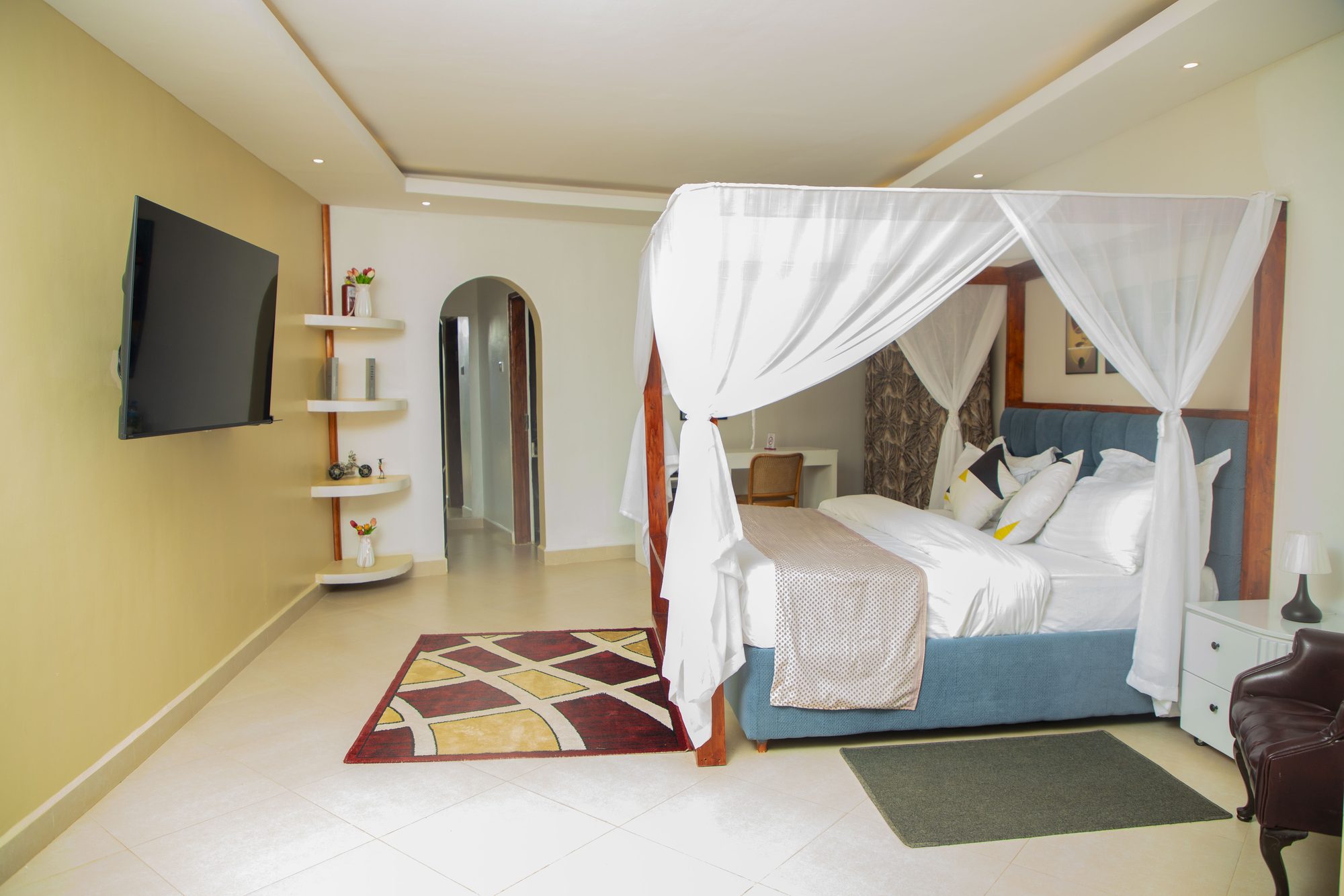 A deluxe room with a four-poster canopy bed at Saivilla Hotel