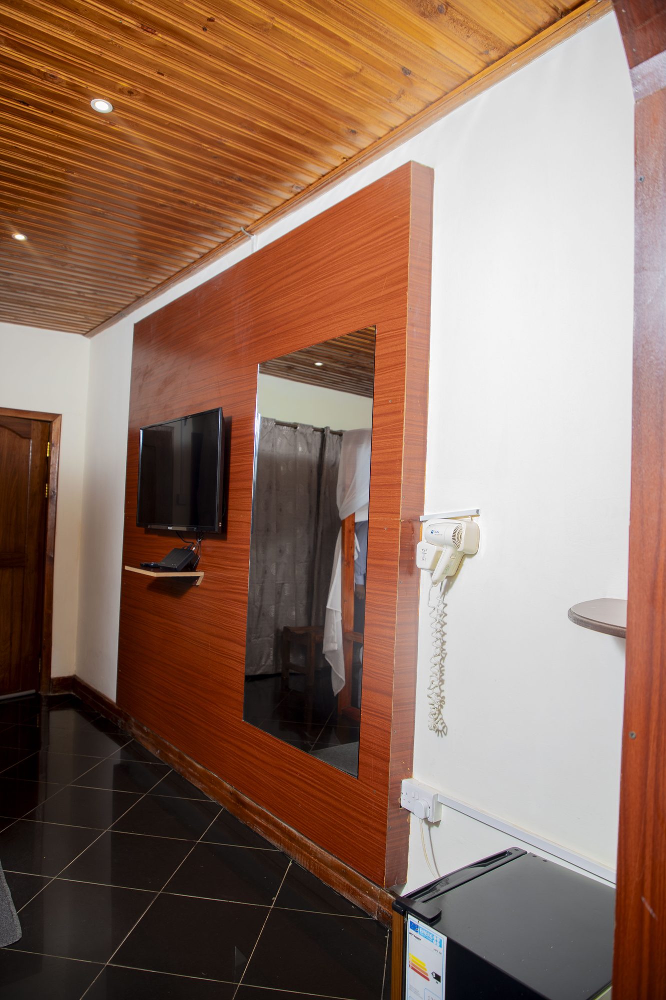 Flat-screen TV and dressing mirror in a Saivilla Hotel room